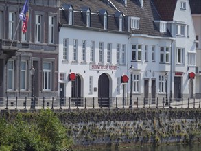A picture of riverside buildings with shutters, taken on a sunny day, Maastricht, Netherlands