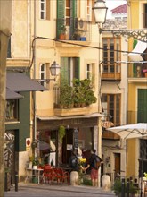 Lively street scene with colourful facades, balconies and a cafe, palma de Majorca with its