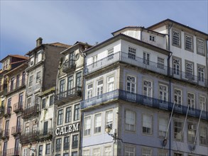 Historic buildings with balconies and elaborate facades in an old town district under a clear sky,