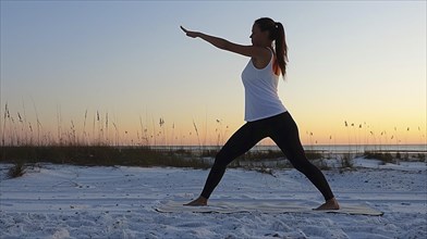 Eine Frau fuehrt eine Yoga-Pose am Strand bei Sonnenuntergang aus, AI generiert, AI generated