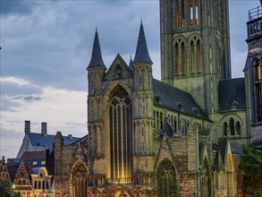 Gothic church with high towers and large windows, evening lighting, cloudy sky, historic buildings