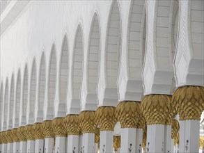 Close-up of arched white columns with golden decorations of Islamic architecture, Abu Dhabi, Arab