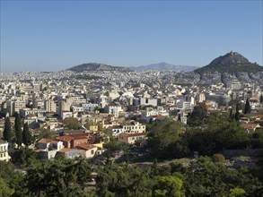 City silhouette with various houses in front of a hilly background, Ancient buildings with columns