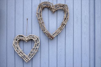 Two hearts made of twigs hanging on a blue wooden door, Southern Palatinate, Palatinate,