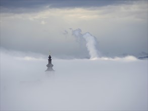 Church tower rises out of the morning mist, Frauenberg pilgrimage church, near Leibnitz, Styria,