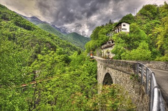 Beautiful Bridge and a House on the Green Mountain Valley with Storm Clouds in Ticino, Switzerland,