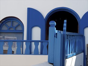A blue and white building with traditional Greek design elements, The volcanic island of Santorini