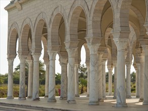 The exterior of a building with marble columns and arches in bright light, Tunis in Africa with