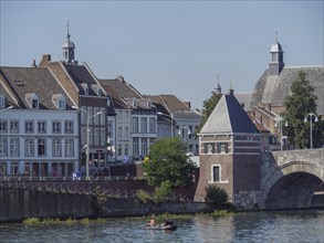 Urban scene with historic buildings and a bridge crossing a river, Maastricht, Netherlands