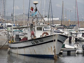 Rustic fishing boat in the harbour, surrounded by other ships and boats, Corsica, ajaccio, France,