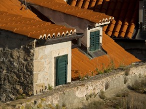 Old buildings with red tiled roofs and green shutters, stone architecture, the old town of