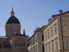 Large church with dome and neighbouring buildings against the blue sky, the old town of Dubrovnik
