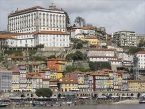 Urban hillside location with colourful houses and a large white building at the top, Colourful