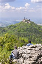 Hikers looking at Hohenzollern Castle near Hechingen, cloudy sky, Zollernalbkreis, Swabian Alb,