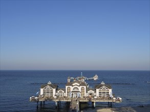 Large building on a pier jutting out into the calm sea, Ruegen, Germany, Europe