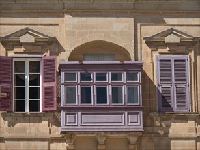 Historic building with purple shutters and balconies, the town of mdina on the island of malta with