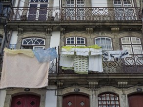 Close-up of balconies with hanging laundry and stone decorations on a historic building, old houses