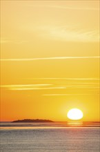 Picturesque, golden, magnificently beautiful sunset over the sea, island Langluetjen II far away,