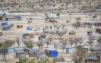 Huts and h of the village Epupa, barren dry landscape with white and yellow hills, Kaokoveld,