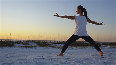 Eine Frau macht Yoga am Strand bei Sonnenuntergang, AI generiert, AI generated