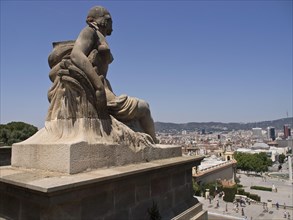 Side view of a large, ornate statue with a view of the cityscape, Barcelona, Spain, Europe