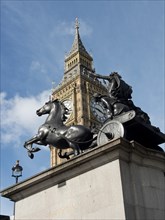 Statue of a chariot with horses in front of Big Ben in London under a cloudy sky, London, England,