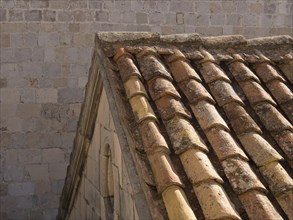 Close-up of an old roof and a stone wall in a medieval town, the old town of Dubrovnik with