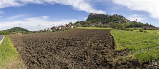 Clods of earth in farmland, Riegersburg Castle in the background, panoramic view, near Riegersburg,