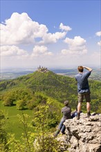 Hikers looking at Hohenzollern Castle near Hechingen, photographer, cloudy sky, Zollernalbkreis,