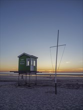Beach hut at sunset, clear lines and colours give the scene a calm atmosphere, setting sun on the