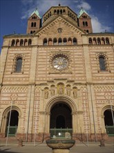 Frontal view of a gothic sandstone cathedral facade with towers under a blue sky, large cathedral