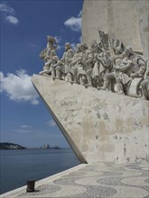 Large stone monument with sculptures on the shore under a blue sky, Lisbon, Portugal, Europe