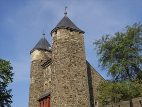 Two impressive stone towers of a historic castle under a clear sky, Maastricht, Netherlands