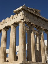 Detail of an ancient temple with doric columns, ancient columns in front of a blue sky, athens,