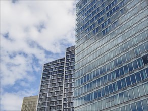 Close-up of modern skyscrapers in Luxembourg with glass facades under a slightly cloudy sky, modern