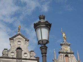 Historic buildings and streetlights under a blue sky and golden statues on the roofs, Historic