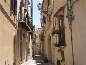 Narrow alley with old buildings and shutters, typical of Mediterranean cities and narrow streets,