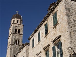 Historic church and stone buildings with green shutters, the old town of Dubrovnik with historic