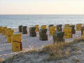 Beach chairs arranged on the beach at sunset, quiet and peaceful, autumn atmosphere on the beach of