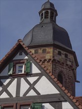 Stone bell tower of a church and half-timbered house in autumn, historic half-timbered houses in