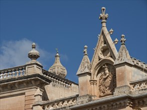 Gothic ecclesiastical architecture with ornate elements and towers under a blue sky, the town of