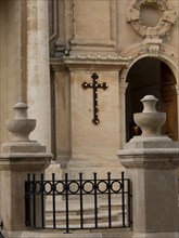 Decorative stone pillars and a black cross on a sandstone church, Valetta, Malta, Europe