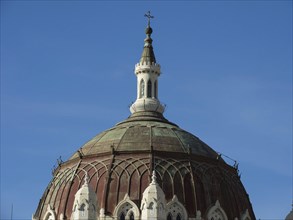 Church dome in detail with clear structure and cross on top in front of blue sky, Madrid, Spain,