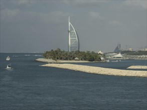 Luxurious hotel on an island with palm trees and boats in a quiet coastal area, Dubai, Arab