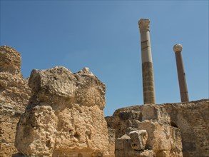 Ancient ruins with high columns and stones under a blue sky, Tunis in Africa with ruins from Roman