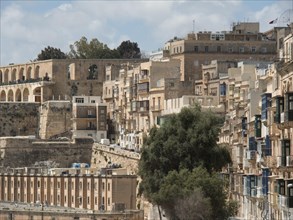 Densely packed old buildings on a hill with historic charm and wide city walls, Valetta, Malta,