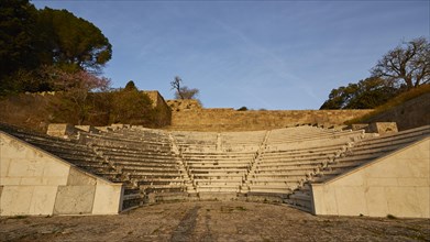Ancient amphitheatre with stone seating steps, captured in the morning light, Archaeological site,