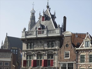 Historic buildings and a church with a hotel in the foreground under a clear blue sky, Haarlem,