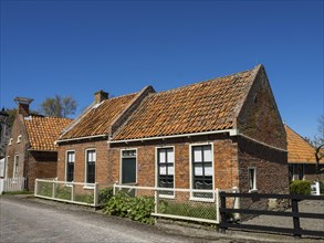 Traditional brick houses with tiled roofs on a quiet, sunny street, Enkhuizen, Nirderlande