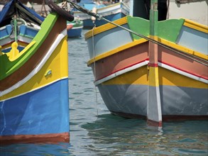 Close-up of two colourfully painted fishing boats anchored in the calm water, Valetta, Malta,